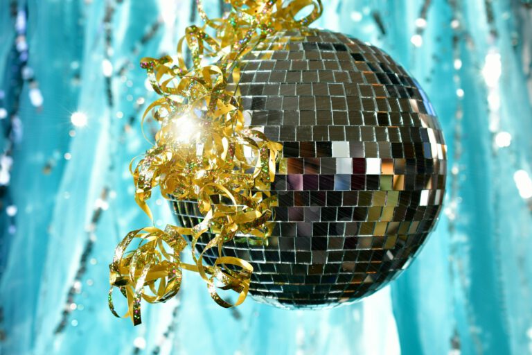 Shiny retro disco ball sparkling in light gold ribbon & shimmering sparkly teal silver background